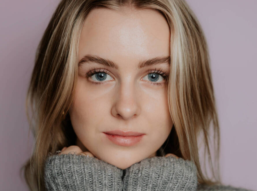 Portretfoto van een jonge vrouw met blauwe ogen en natuurlijk licht, gefotografeerd door Studio Samsam