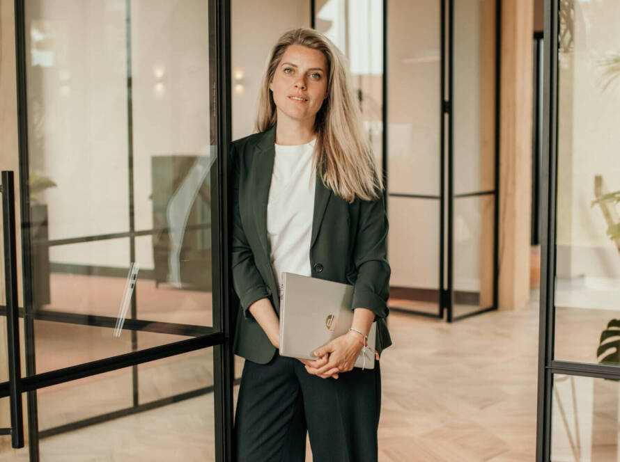 Blonde zakenvrouw met laptop in kantoor – zakelijke portretfotografie door Studio SamSam