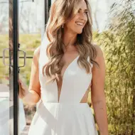 Bruid Kelly in moderne trouwjurk bij trouwlocatie Paviljoen Puur in Diemen.